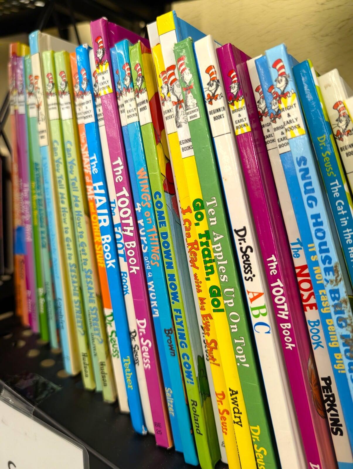 A row of dozens of Dr Seuss books sit on a shelf